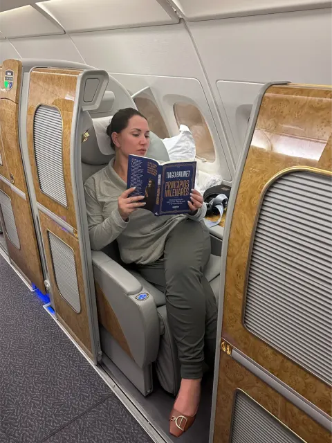 Clea leyendo en su asiento de First Class de Emirates
